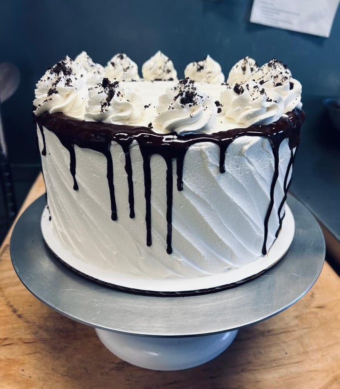 Layered cake with chocolate drip and whipped cream