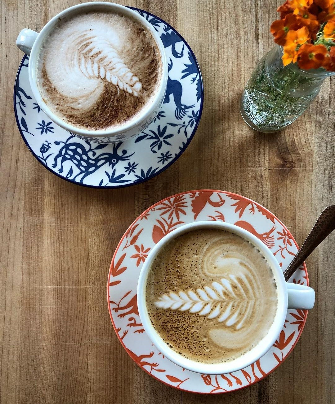 Two cappuccinos on patterned saucers